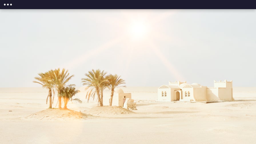lens flare effect on desert landscape with building and palm trees