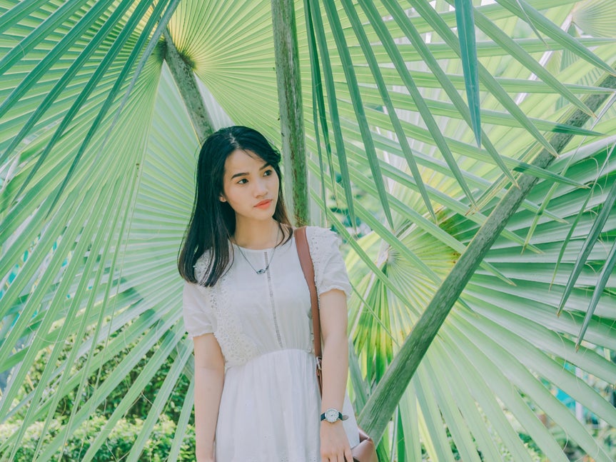 Photo of woman with greenery in the background