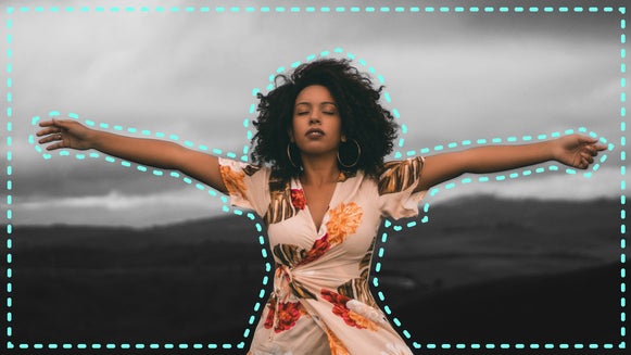 Woman in field with black and white effect applied selectively to the landscape background