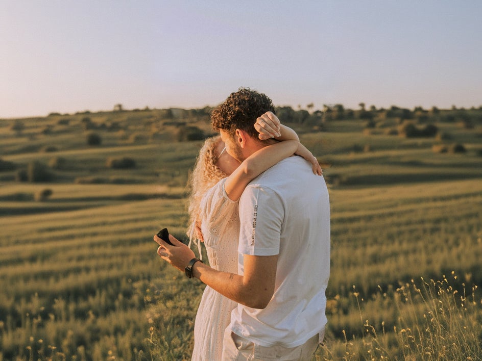 engagement photo of couple standing in field