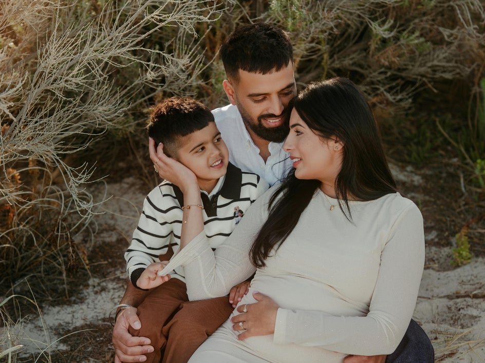 Family of three posing in natural outdoor light