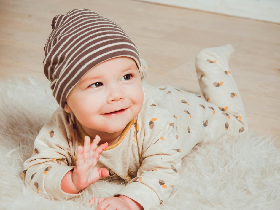 Baby portrait with beige background and footie pajamas