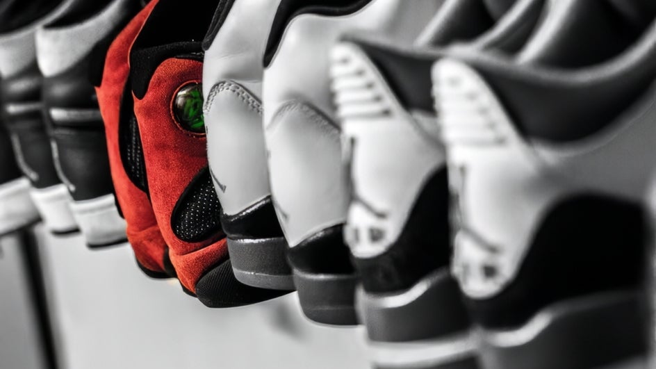 Row of sneakers in black and white with single pair colorized to dramatize and draw attention from the rest