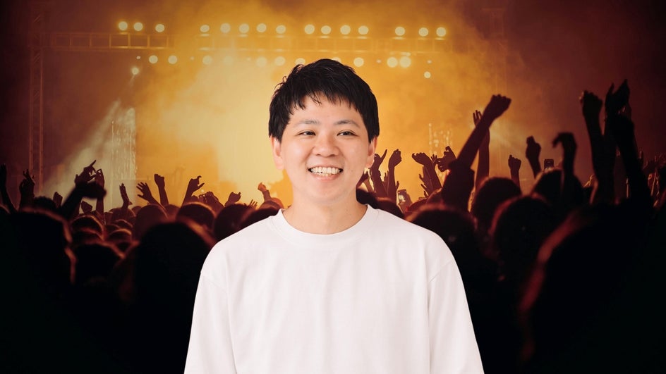 Man in virtual meeting with concert as funny zoom background.