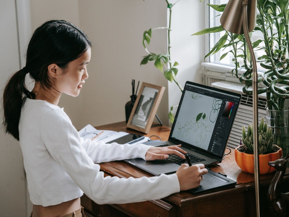 Woman at laptop creating illustration for children's book